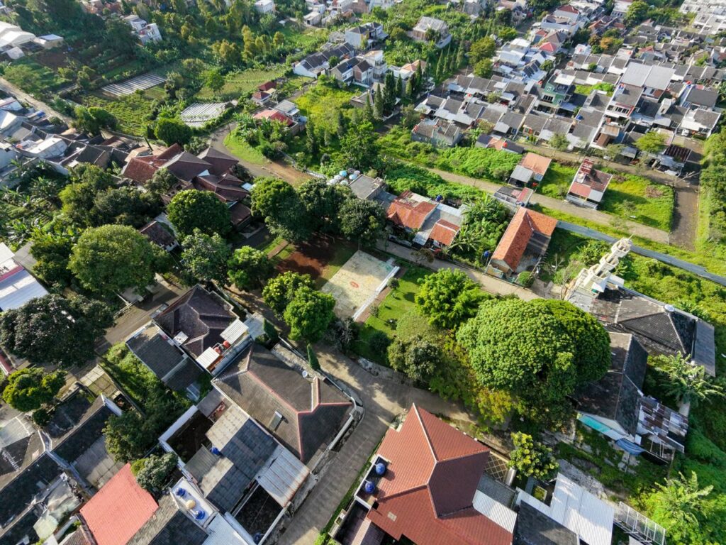 Aerial shot showcasing vibrant residential neighborhood surrounded by abundant greenery and diverse architecture.
